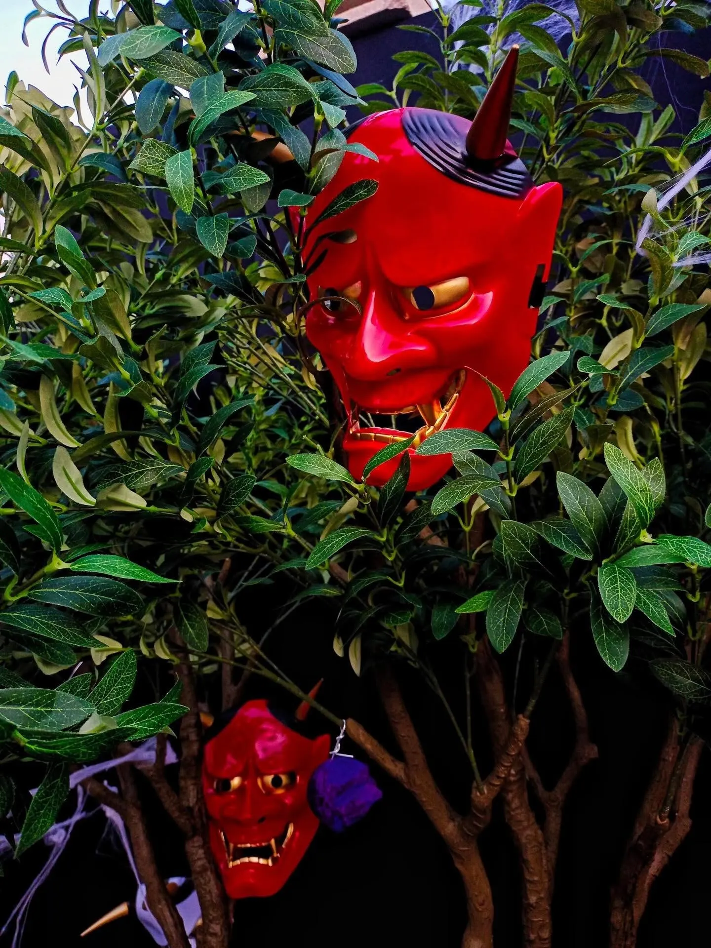 Máscaras rojas de oni entre hojas verdes